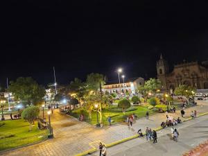a group of people walking around a park at night at Cozzy apartment en pleno Centro! in Ayacucho