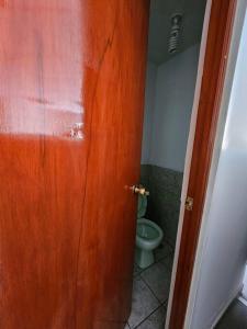 a door leading to a bathroom with a toilet at Cozzy apartment en pleno Centro! in Ayacucho