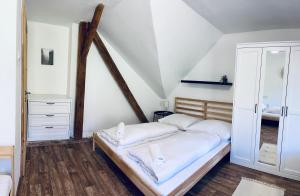 a bedroom with a bed with white sheets at Chalupa Bořanovice in Vimperk