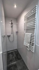 a white bathroom with a shower and a towel at Apartments am Rheingarten in Cologne