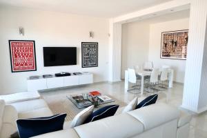 uma sala de estar branca com um sofá branco e uma mesa em Lux 180sqm flat - entire last floor em Milão
