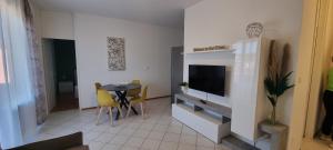 a living room with a table and a tv in a room at Al Nido Della Stazione in Lugano