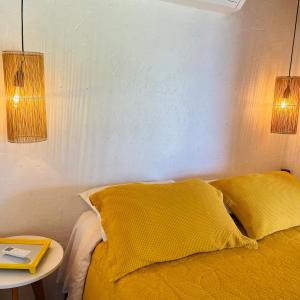 1 dormitorio con 1 cama con 2 almohadas amarillas y mesa en Cabana Alpha - Pousada Colina dos Ventos, en Urubici