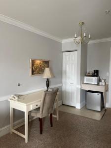 Habitación con escritorio y mesa con lámpara. en Selinsgrove Inn en Selinsgrove