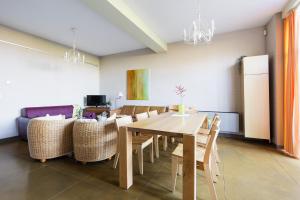 a dining room with a wooden table and chairs at Domein Tombos in Gingelom