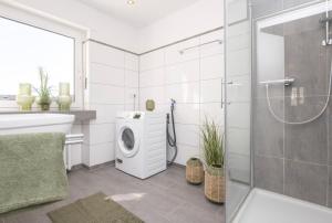 uma casa de banho com uma máquina de lavar roupa e um chuveiro em Center Dream Apartment - Netflix em Krefeld