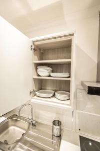kuchnia ze zlewem i talerzami w szafce w obiekcie EXECUTIVE APARTMENTS free on-site parking, 2 en-suites, sleeps 4, w mieście Swindon