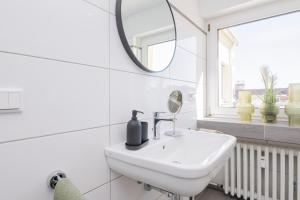 a white bathroom with a sink and a mirror at Center Dream Apartment - Netflix in Krefeld +11 photos