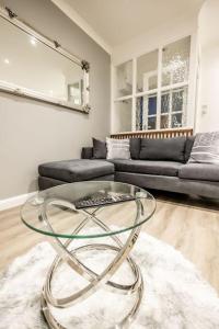 a living room with a glass table and a couch at EXECUTIVE APARTMENTS free on-site parking, 2 en-suites, sleeps 4, in Swindon