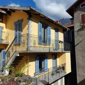 ein gelbes Gebäude mit blauen Fensterläden und Balkonen in der Unterkunft Casa Labirinto vakantie-appartementen in Barna