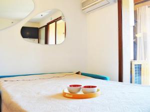 duas taças numa bandeja numa cama com um espelho em Appartement Bormes-les-Mimosas, 1 pièce, 4 personnes - FR-1-251-77 em Bormes-les-Mimosas