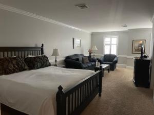 a bedroom with a bed and two chairs and a couch at Selinsgrove Inn in Selinsgrove