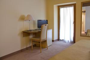 a bedroom with a desk with a computer and a chair at Hotel Dependance Silvestro in Garda