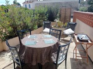 stół i krzesła na patio w obiekcie Charmant studio fonctionnel avenue des alliés w mieście Cavalaire-sur-Mer