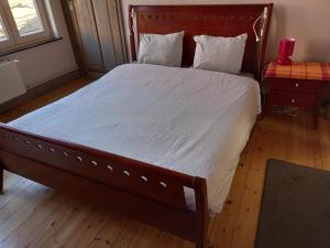 een slaapkamer met een groot bed met een houten frame bij Guesthouse Oude Houtmarkt in Ieper