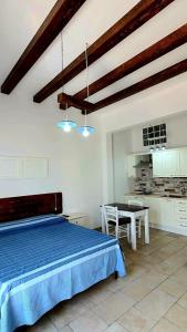 a bedroom with a blue bed and a table at Lu Salentu Chalet Beach in Marina di Mancaversa