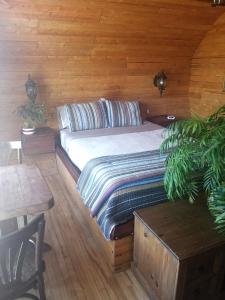 Cama en habitación con pared de madera en L'Oasis du Pirate, en Quebec