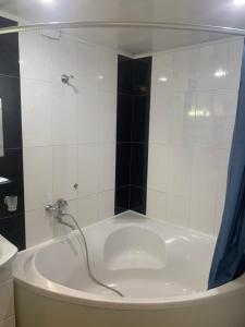 a bathroom with a tub with a blue shower curtain at Cozy and comfortable apartment in Cherkasy +17 photos