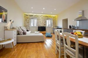 a kitchen and a living room with a couch and a table at Beau Maison in Corfu