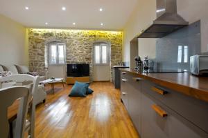 uma cozinha e uma sala de estar com uma mesa em Beau Maison em Corfu Town