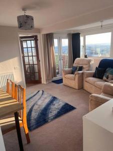 a living room with a couch and chairs and a table at Bay View Retreat in Paignton