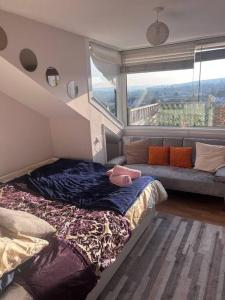 a bedroom with a bed and a couch and a window at Bay View Retreat in Paignton