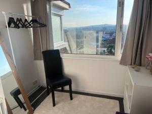 a black chair sitting in a room with a window at Bay View Retreat in Paignton