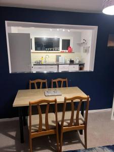 a table and chairs with a kitchen in the background at Bay View Retreat in Paignton