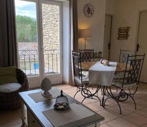 een woonkamer met een tafel en stoelen en een eetkamer bij Bastidon à Gordes avec piscine in Gordes