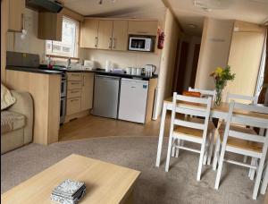 a kitchen and living room with a table and chairs at Gorgeous 3 bed static caravan at Hoburne Devon Bay, pet friendly in Paignton
