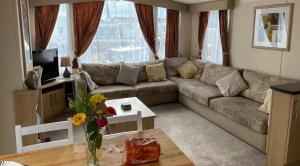 uma sala de estar com um sofá e uma mesa em Gorgeous 3 bed static caravan at Hoburne Devon Bay, pet friendly em Paignton