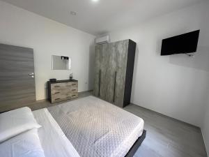 a bedroom with a bed and a flat screen tv at Il nido d'amore in Paola