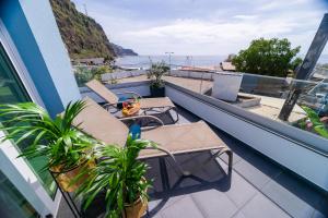 balcón con 2 mesas y vistas al océano en Blue House en Ponta do Sol