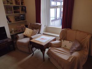 Una sala de estar con dos sillas y una mesa de café. en Remarkable 3-Bed House in Millom, en Millom