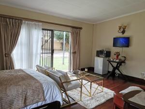 Johannesburg的住宿－Exclusive Private Room in Joburg No loadshedding，一间卧室配有一张床、一张桌子和一台电视。
