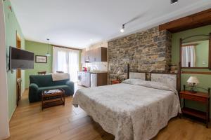 1 dormitorio con cama y pared de piedra en Casa Dieste Apartamentos Turísticos en Boltaña en Boltaña