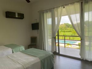 1 dormitorio con 2 camas y ventana con vistas en Miotrakasa, en Cahuita