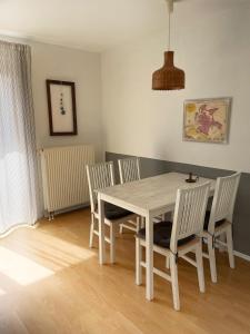 a dining room with a white table and chairs at Gemütliche 2 Zi-FeWo mit Terrasse, Strandnähe, WIFI in Breege