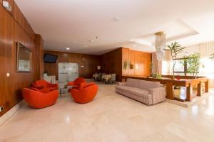 a large living room with orange chairs and a table at Hotel Faranda Los Tilos in Teo