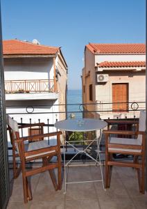 un patio con 2 sillas y una mesa en el balcón en Mare e Pietra, en Monemvasia