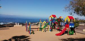 a playground on the beach with the ocean in the background at Cheyma Home 3º: Amplio apartamento en Alcalá in Alcalá