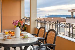 a table with food and flowers on a balcony at LE TERRAZZE apartments in Alghero