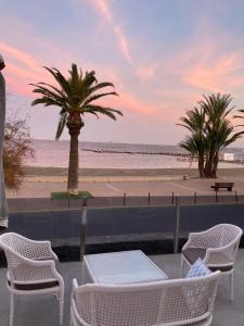 vistas a una playa con sillas y palmeras en Casa Cary, en Santiago de la Ribera