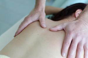 una mujer recibiendo un masaje de espalda de un terapeuta en Hotel Alpengasthof Löwen en Bad Hindelang