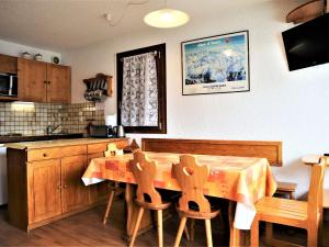 een keuken met een houten tafel met stoelen en een aanrecht bij Appartement Auris, 2 pièces, 6 personnes - FR-1-297-26 in Auris