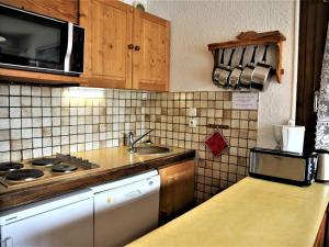 een keuken met een wastafel en een fornuis top oven bij Appartement Auris, 2 pièces, 6 personnes - FR-1-297-26 in Auris
