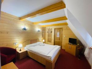 a small bedroom with a bed and a television at Casa Chira in Vişeu de Sus