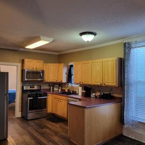 a kitchen with wooden cabinets and a stove top oven at Central 1 Bd in Fountain Square- Walk 5 Min to Downtown in Indianapolis