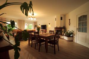 a dining room and living room with a table and chairs at Kwintesencja Natury in Stobnicko