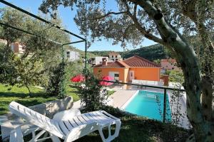 a white chair sitting next to a swimming pool at Villa Marietta Equino in Donje Sitno